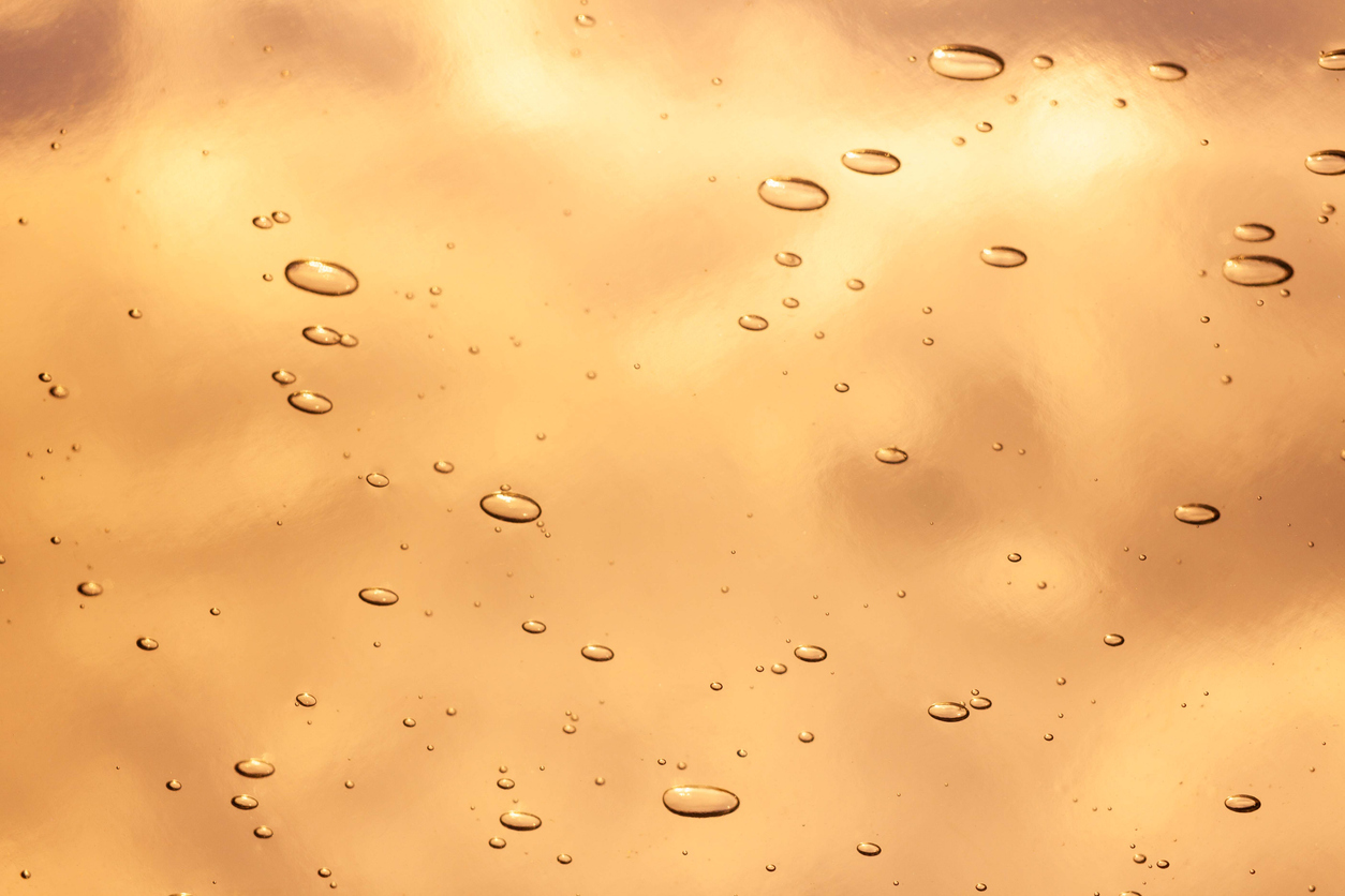 Orange gold tangerine yellow light cosmetic texture. Gel smudge swatch on background.